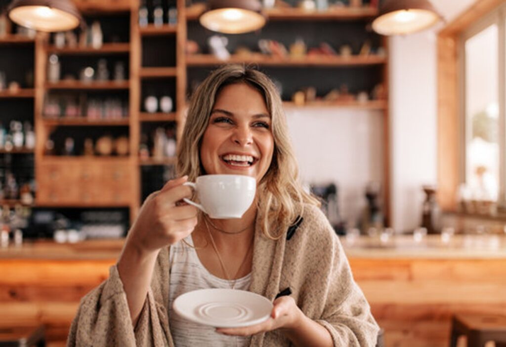 Mulher feliz segurando uma xícara de café.