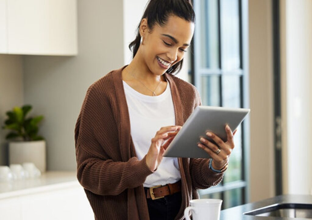 Mulher feliz olhando um tablet.